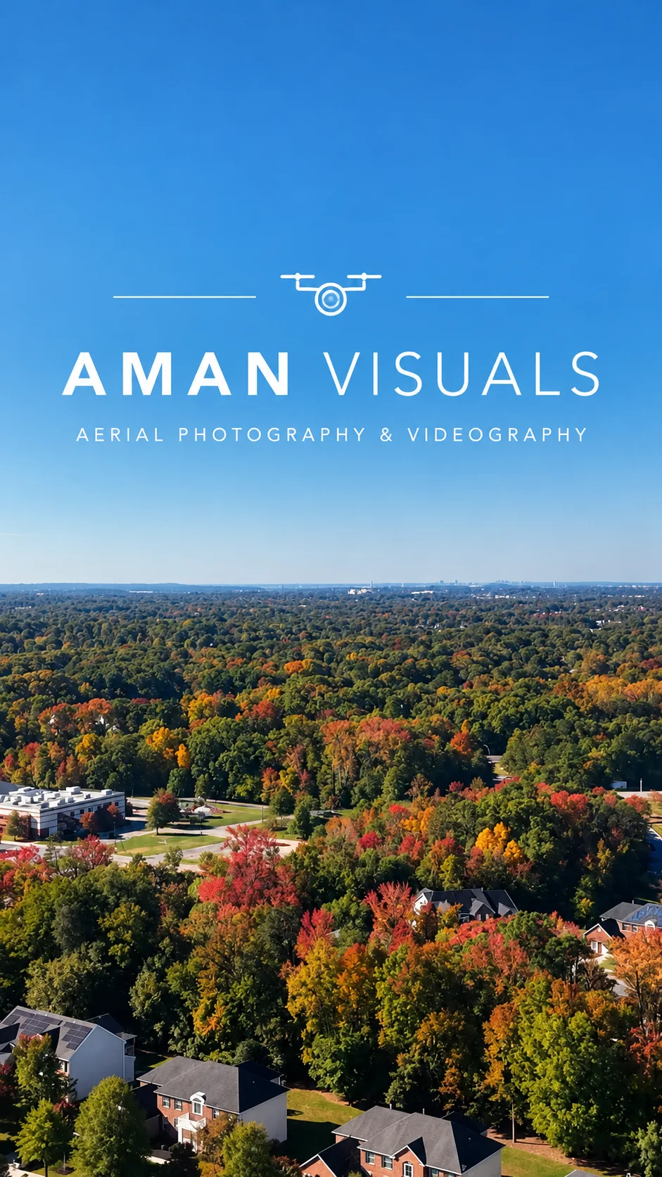 Aerial view of a Maryland neighborhood in autumn colour, red and gold tree canopy under a clear blue sky